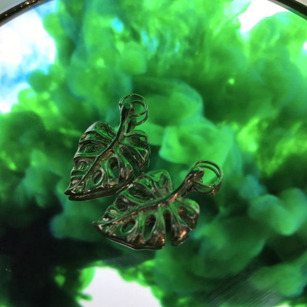 en bild på en berlock med temat blad med grön bakgrund 